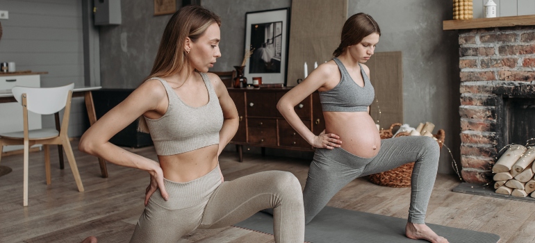 A pregnant woman working out with a prenatal personal trainer UAE