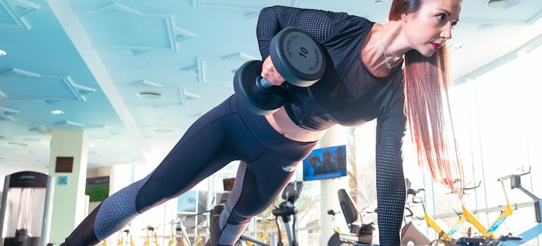 A woman working out with dumbbells, who represents hiring weight loss coach UAE