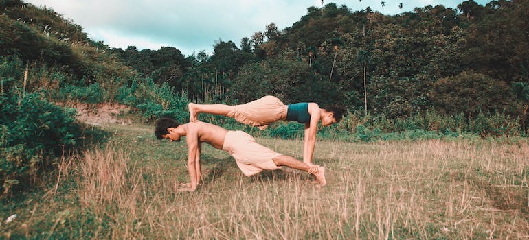 A boy and a girl doing yoga poses together. 