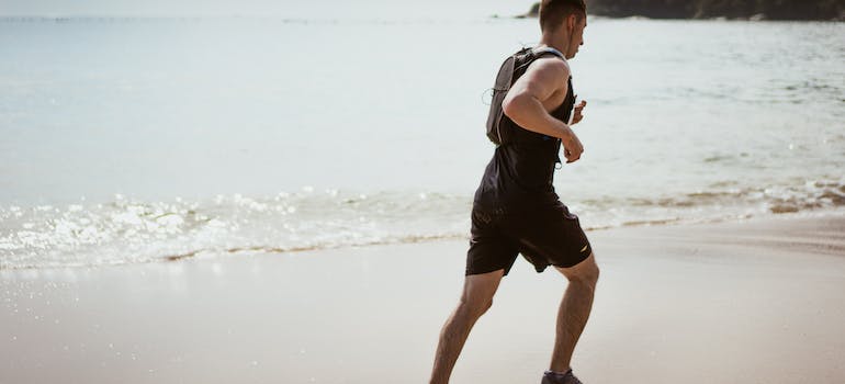 A man running on a beach in Abu Dhabi to Experience the health benefits of outdoor fitness in Abu Dhabi.