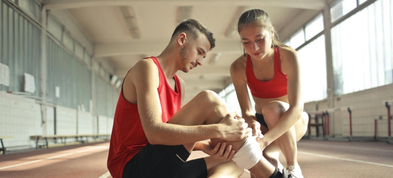 A woman helping a man with all the essential equipment for post-injury training.
