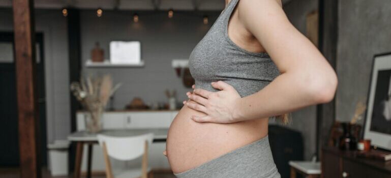 A pregnant woman holding her belly.