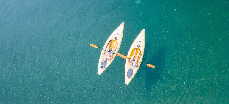 A couple enjoying kayaking together as one of the best healthy date ideas. 