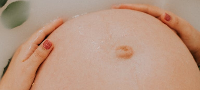 a pregnant woman holding her stomach