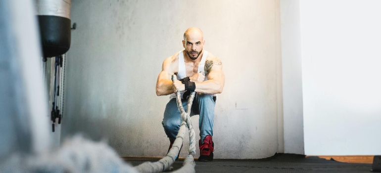 a man doing rope exercises in a gym