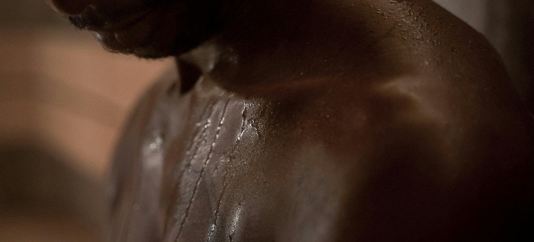 a close-up of a shirtless man with wet skin