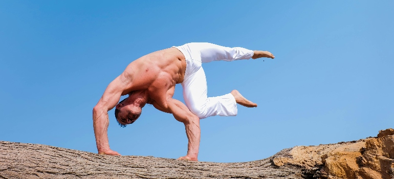 a man doing Ashtanga yoga on a rocky surface