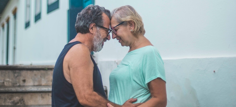 A man and a woman standing next to a house