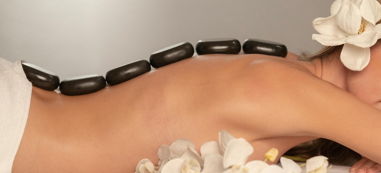 Black Stones on a woman's back, after visiting couples wellness and spa retreats in Abu Dhabi.