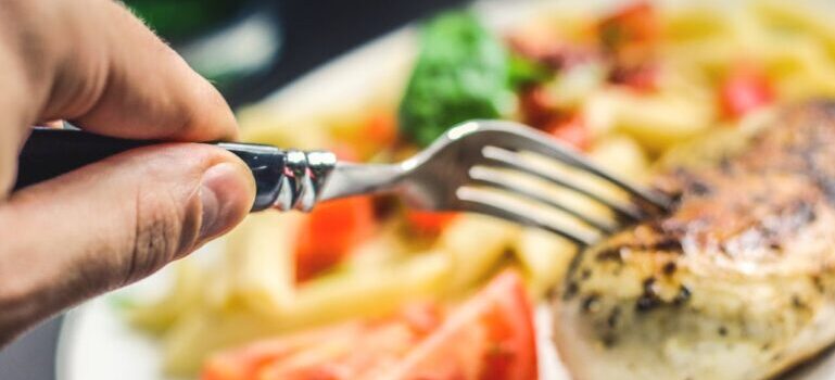 A person holding a silver fork in one of the healthy lifestyle restaurants in Ras Al Khaimah