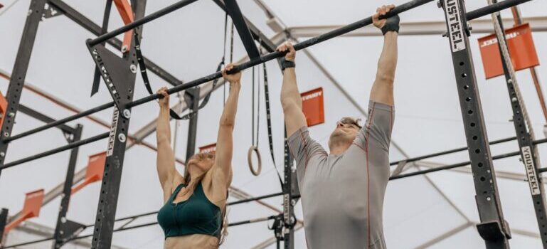 A man and woman doing pull-ups