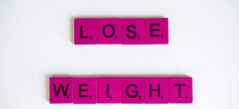 A pink and black letter tiles that say "Lose Weight"