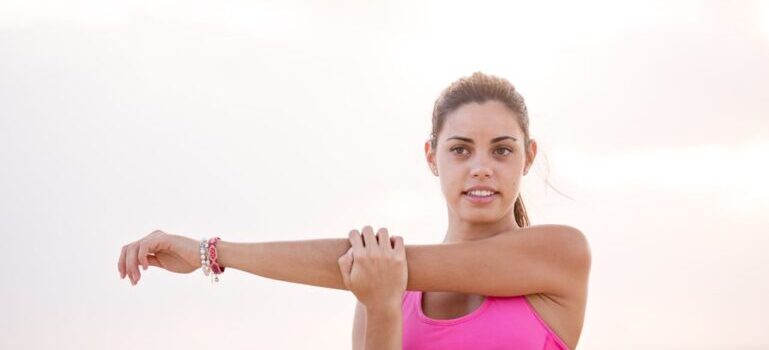 A woman wearing pink t-shirt and exercising