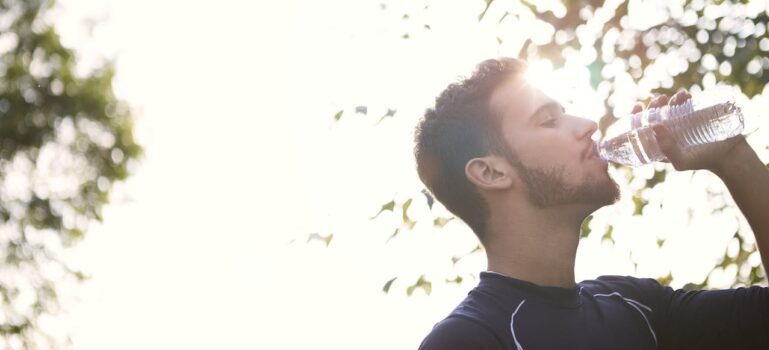 A man drinking water and exercising