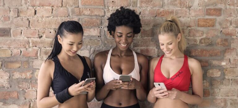 Three women holding their phones