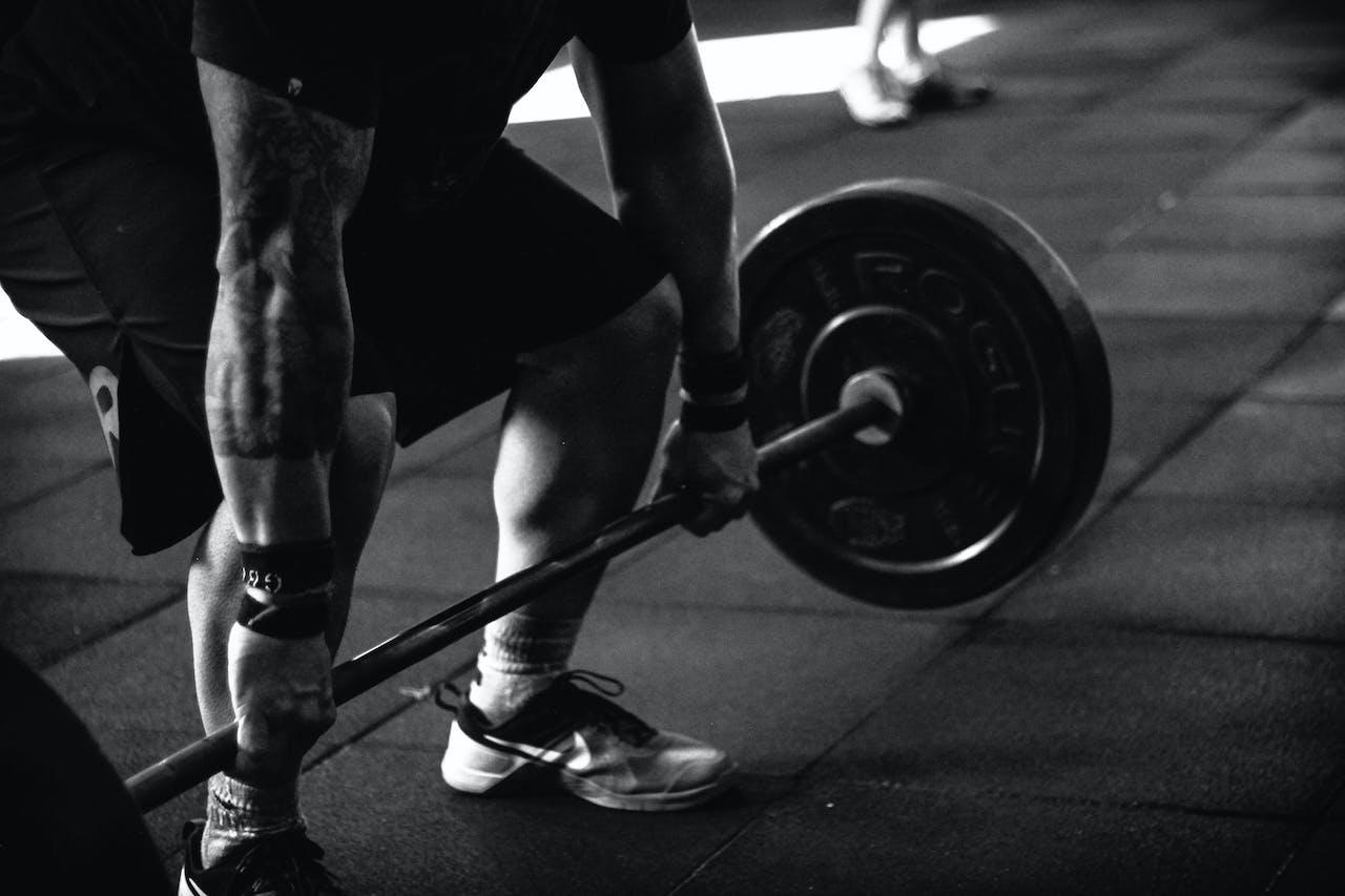 A black and white photo of a man doing a dead lift