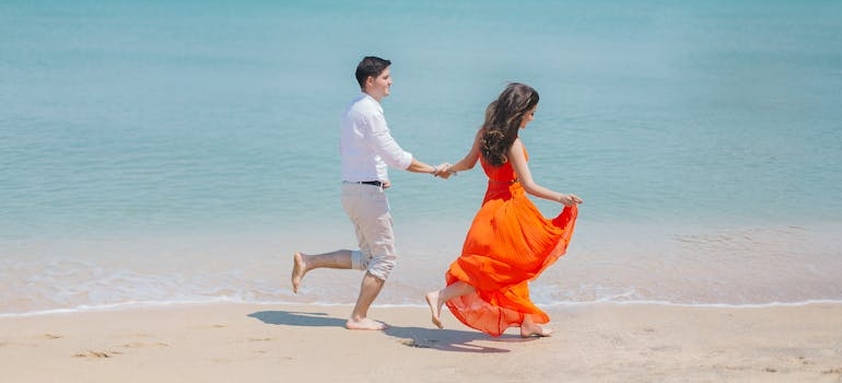 a couple walking along the beach after learning about healthy date ideas they can try