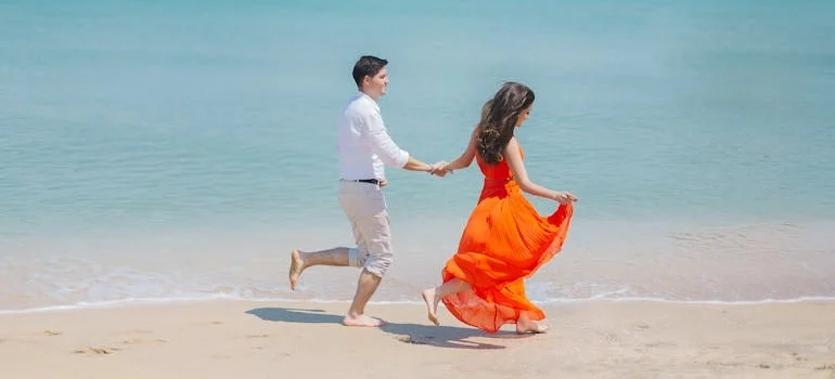 a couple walking along the beach after learning about healthy date ideas they can try