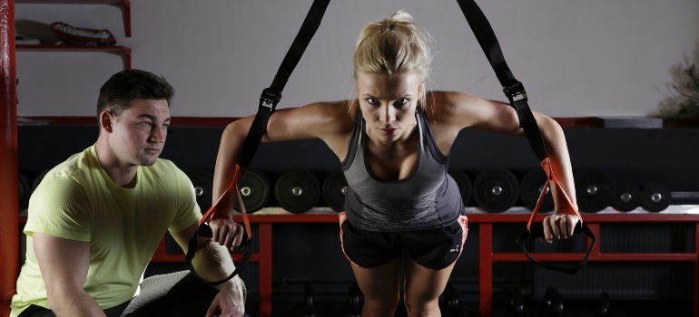 A woman doing an exercise with a fitness trainer