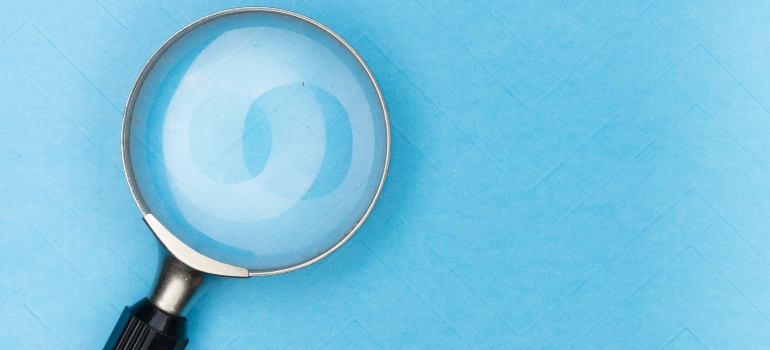 A magnifying glass on a blue surface 