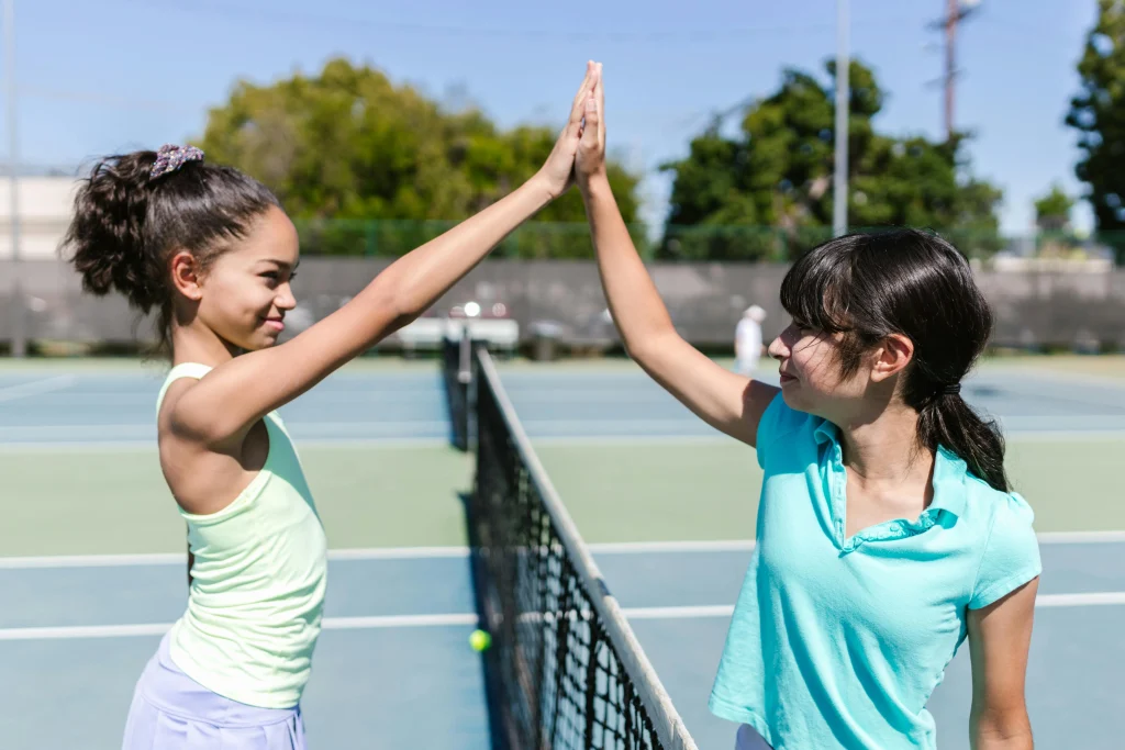 Two teenage girls high fiving each other.