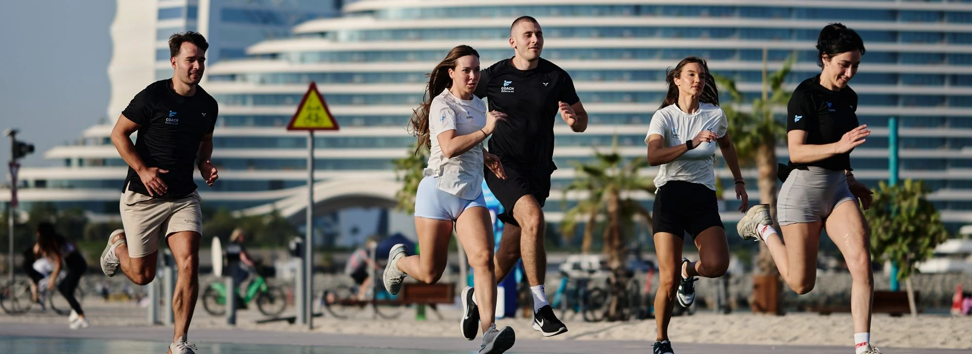 FitForce coaching team and clients on a group run at Umm Suqeim beach, Dubai