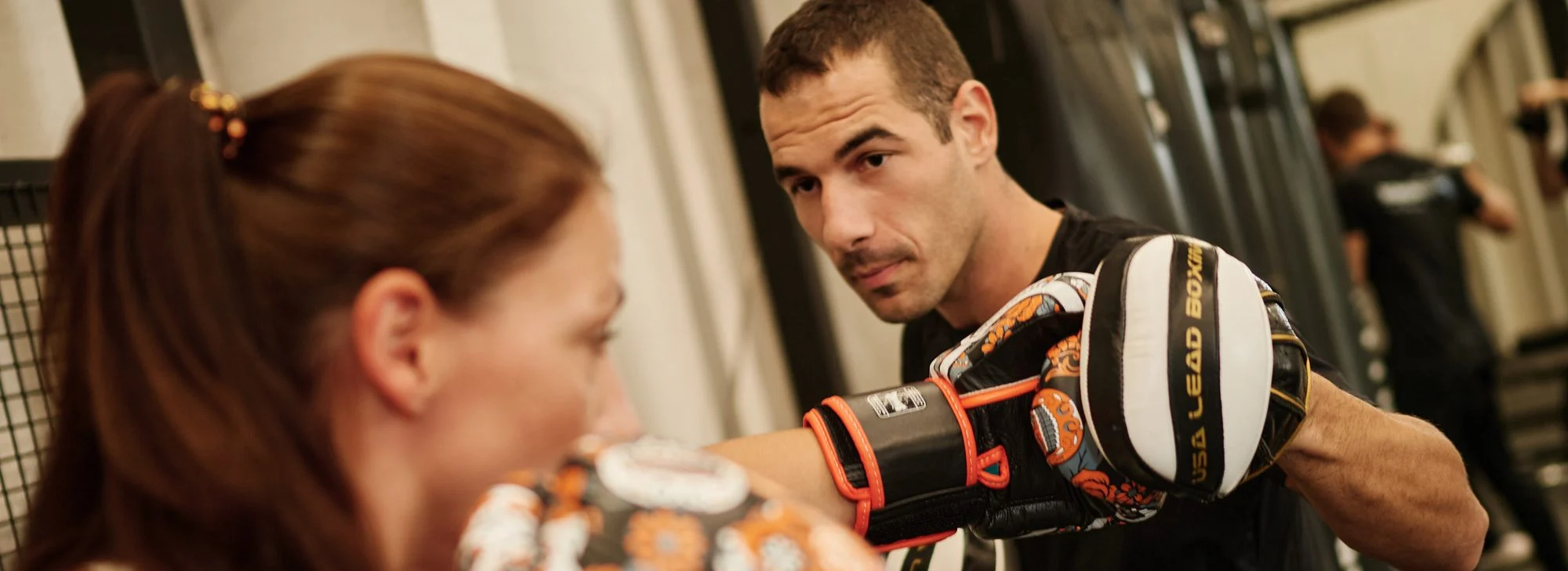 Boxing personal training session with pads and gloves in a Dubai gym